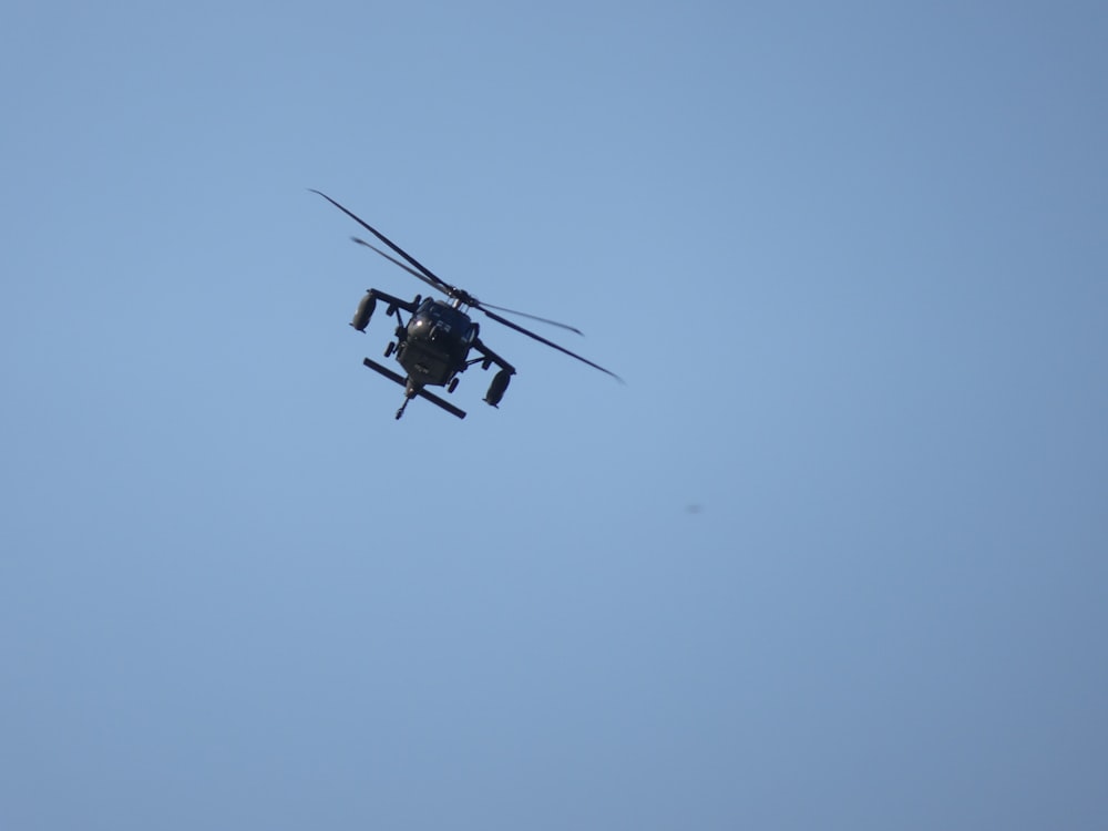 a helicopter flying through a blue sky on a clear day