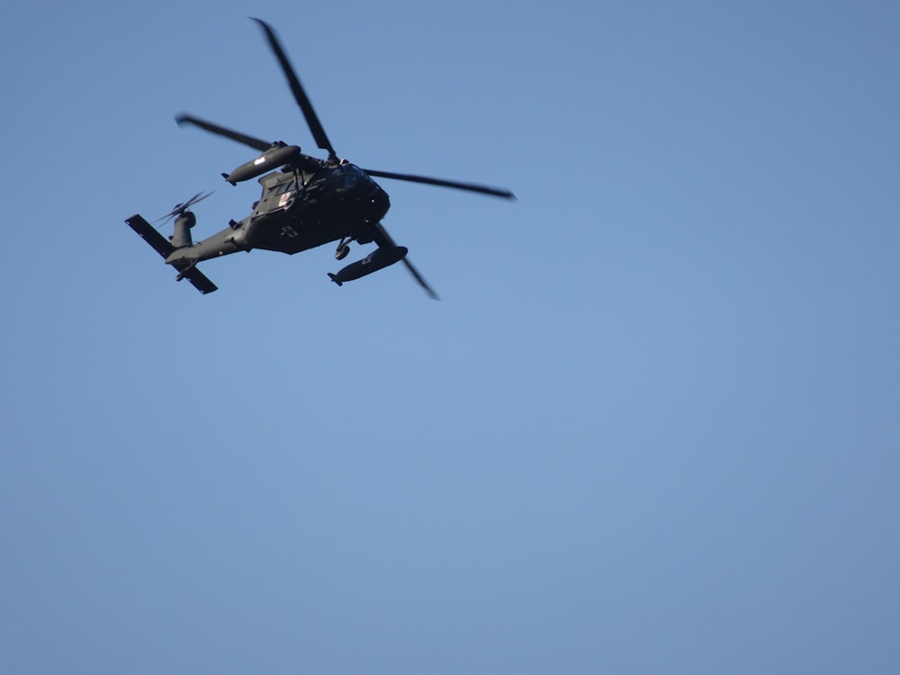 a helicopter flying through a blue sky on a sunny day