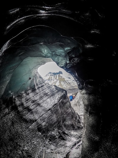 a large ice cave with a mountain in the background