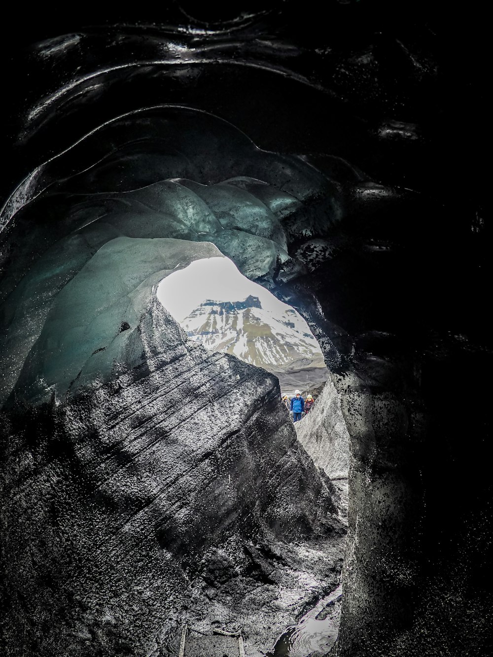 a large ice cave with a mountain in the background