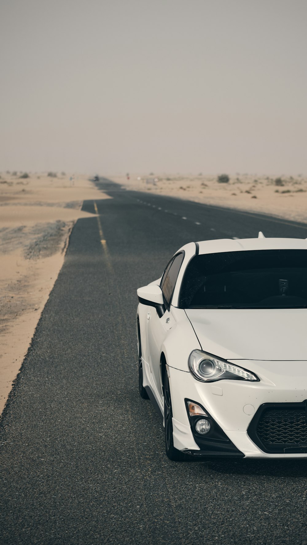 a white sports car parked on the side of the road