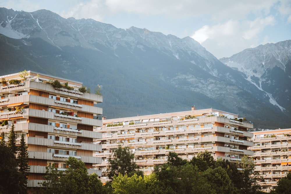 a group of apartment buildings with mountains in the background