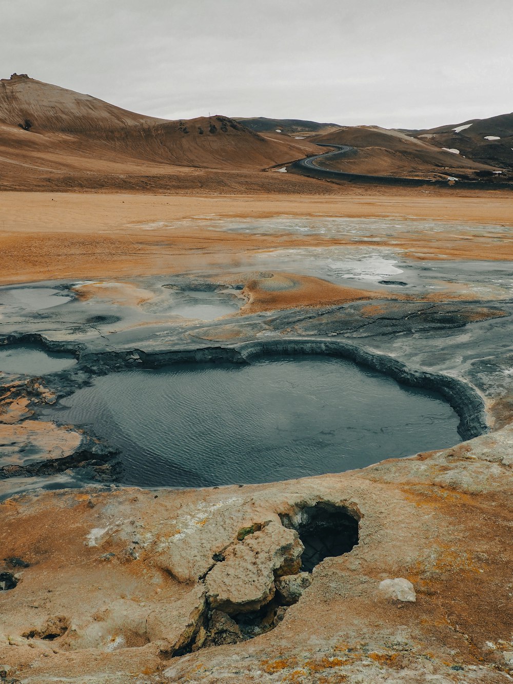 a small pool of water in the middle of a desert