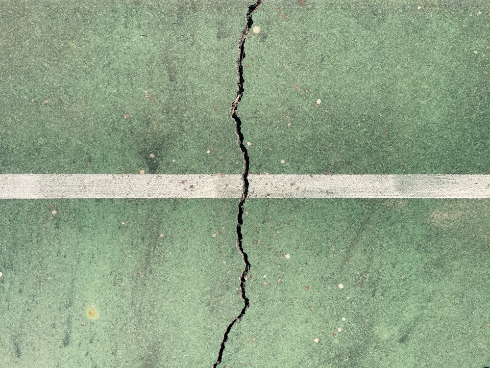 a crack in the ground with a white line going through it