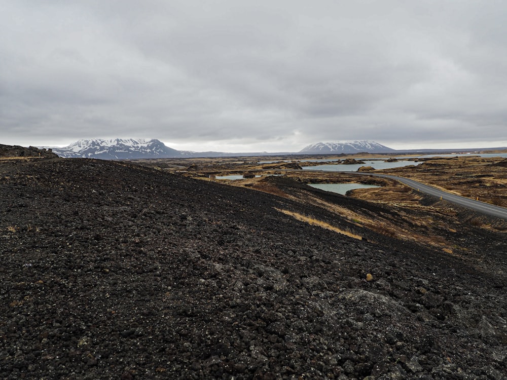 a road going through a barren landscape with mountains in the background