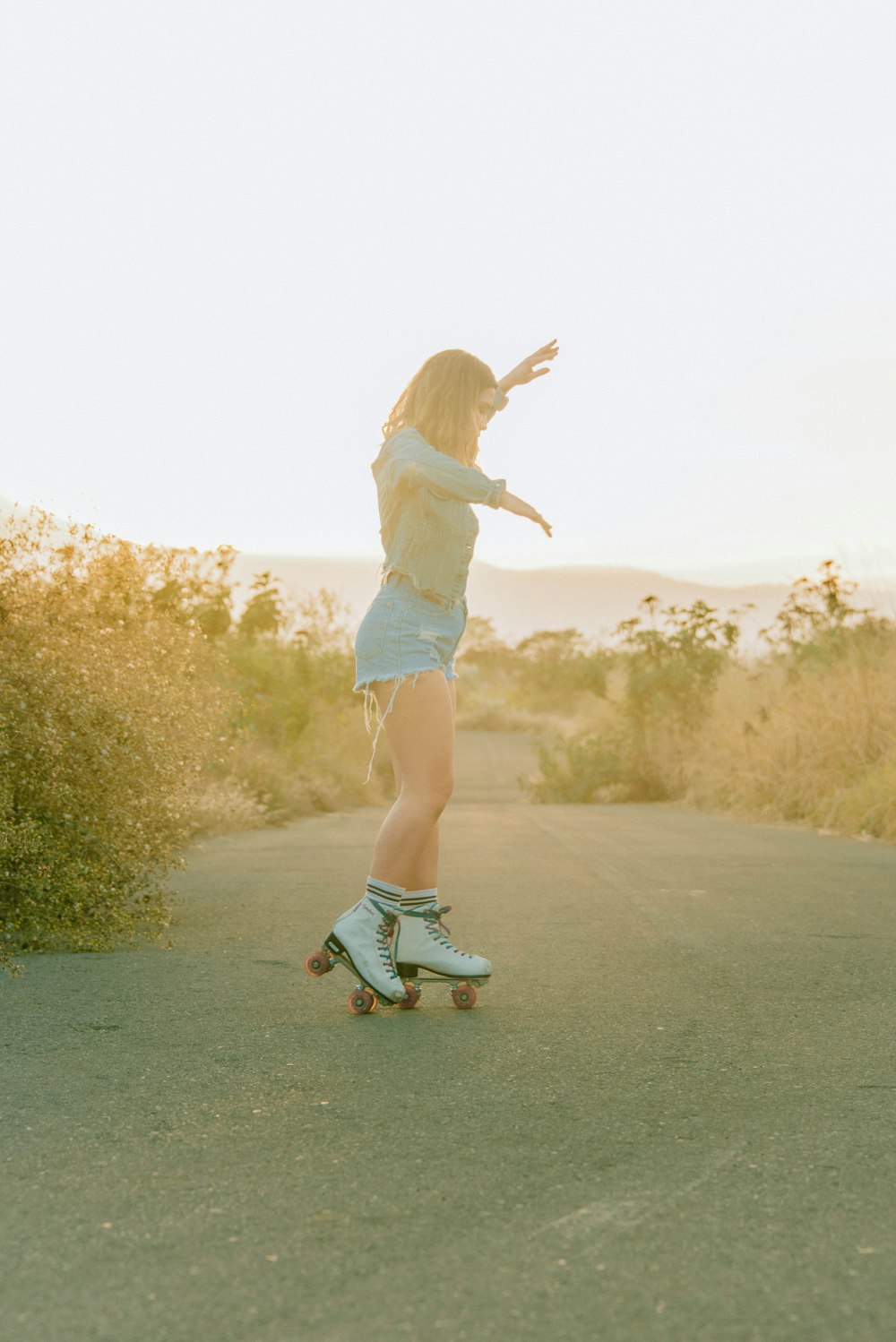 a woman riding a skateboard down a road