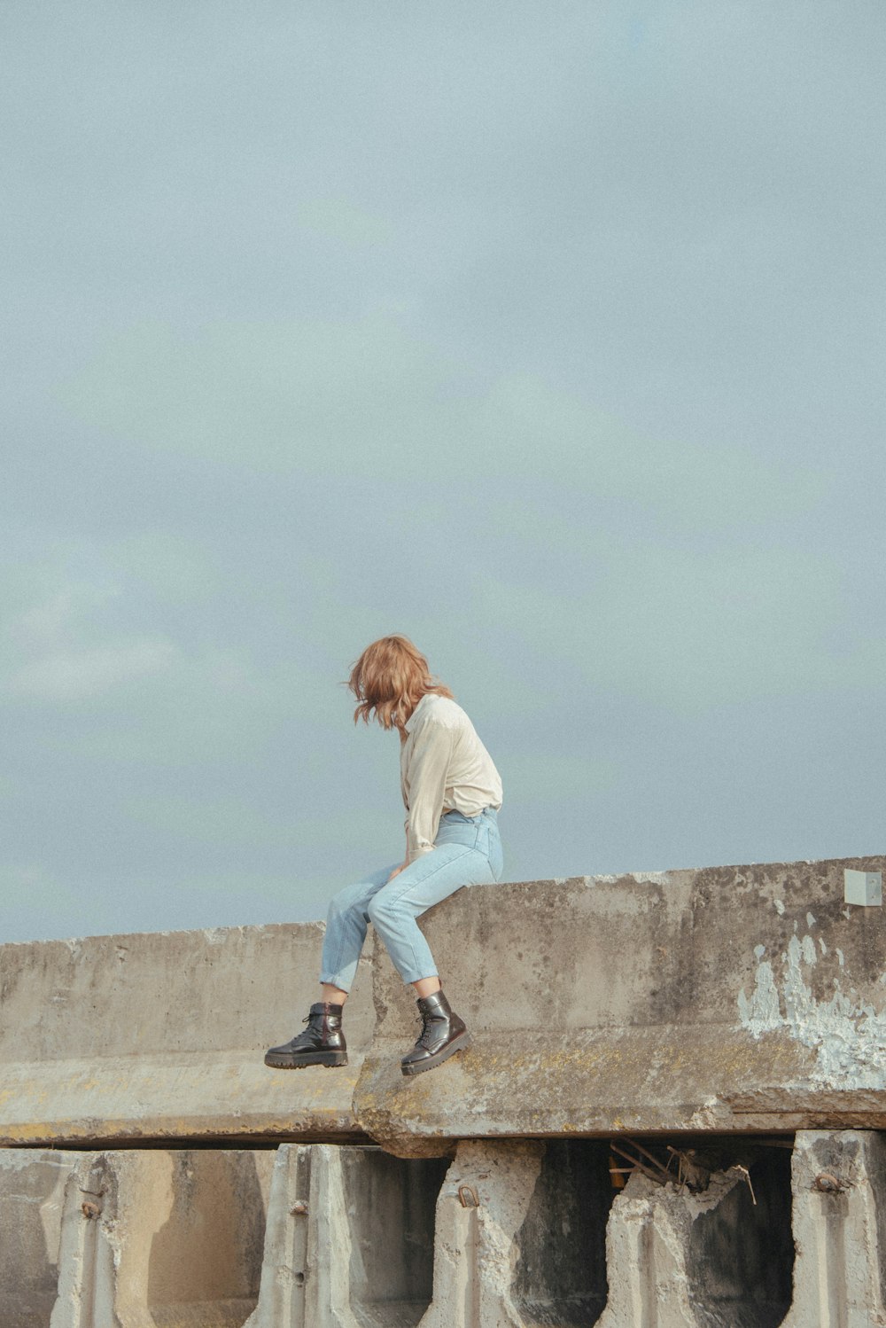 a young man riding a skateboard on top of a cement wall