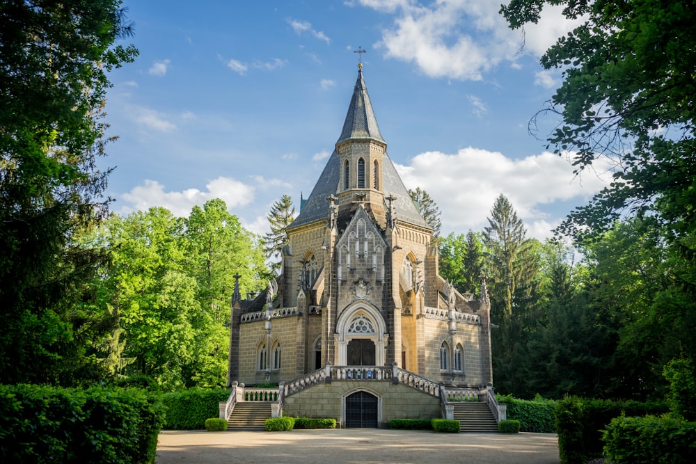 a large building with a steeple surrounded by trees