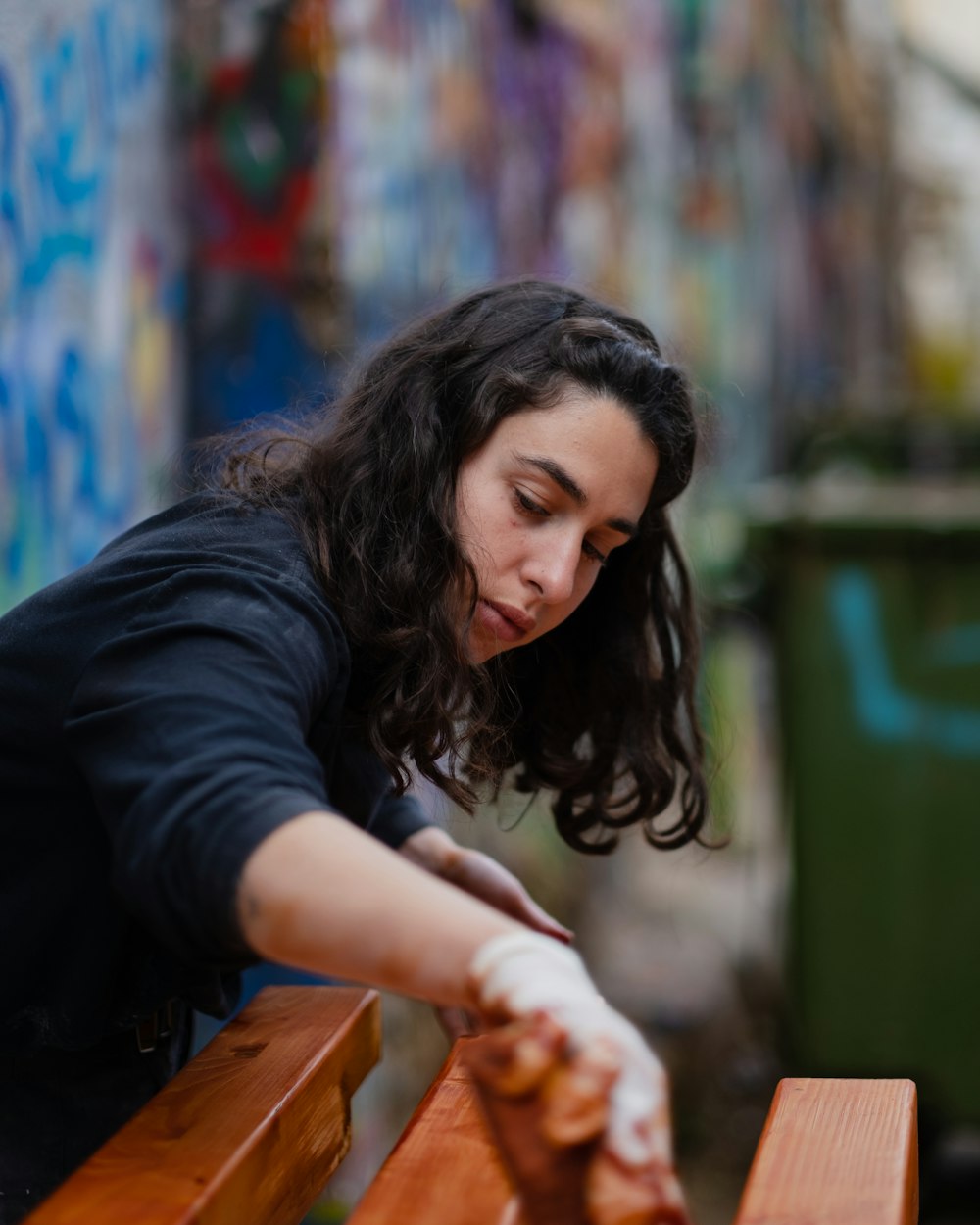 a woman is leaning over a wooden bench