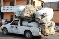a white truck with a bunch of bags on the back of it