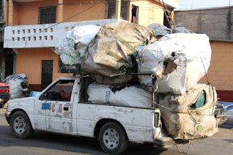 a white truck with a bunch of bags on the back of it