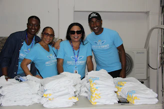 a group of people standing next to a pile of cloth