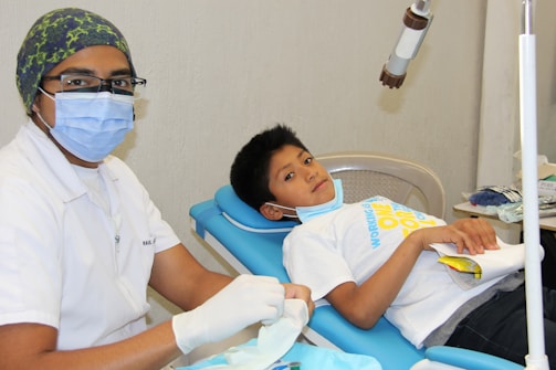 a young boy getting his teeth checked by a dentist