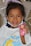 A happy child wearing a colorful hair bow from Alice.