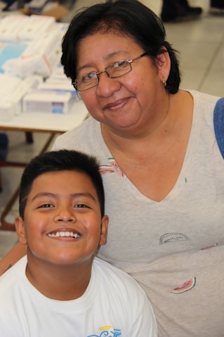 a woman standing next to a young boy