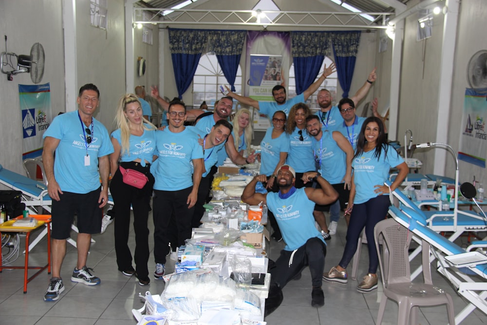 a group of people in blue shirts posing for a picture