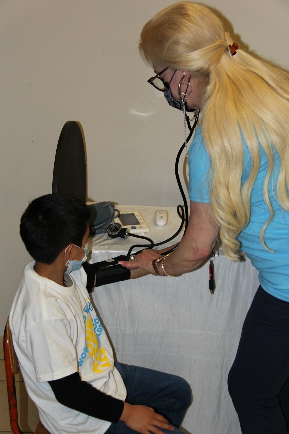 a woman is listening to a boy with a stethoscope