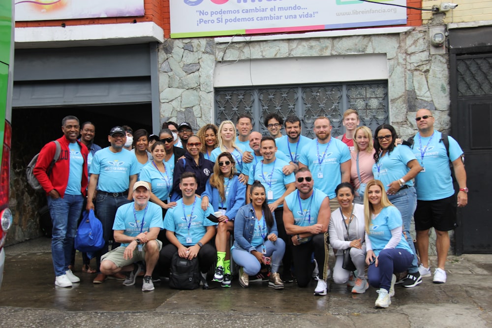 a group of people in blue shirts posing for a picture