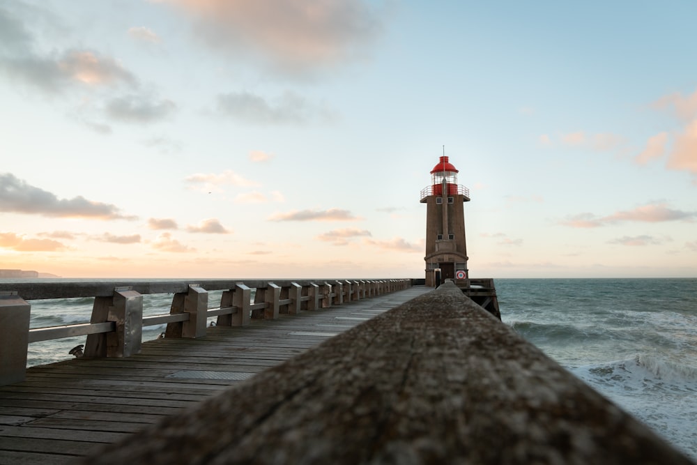 a light house sitting on top of a pier next to the ocean