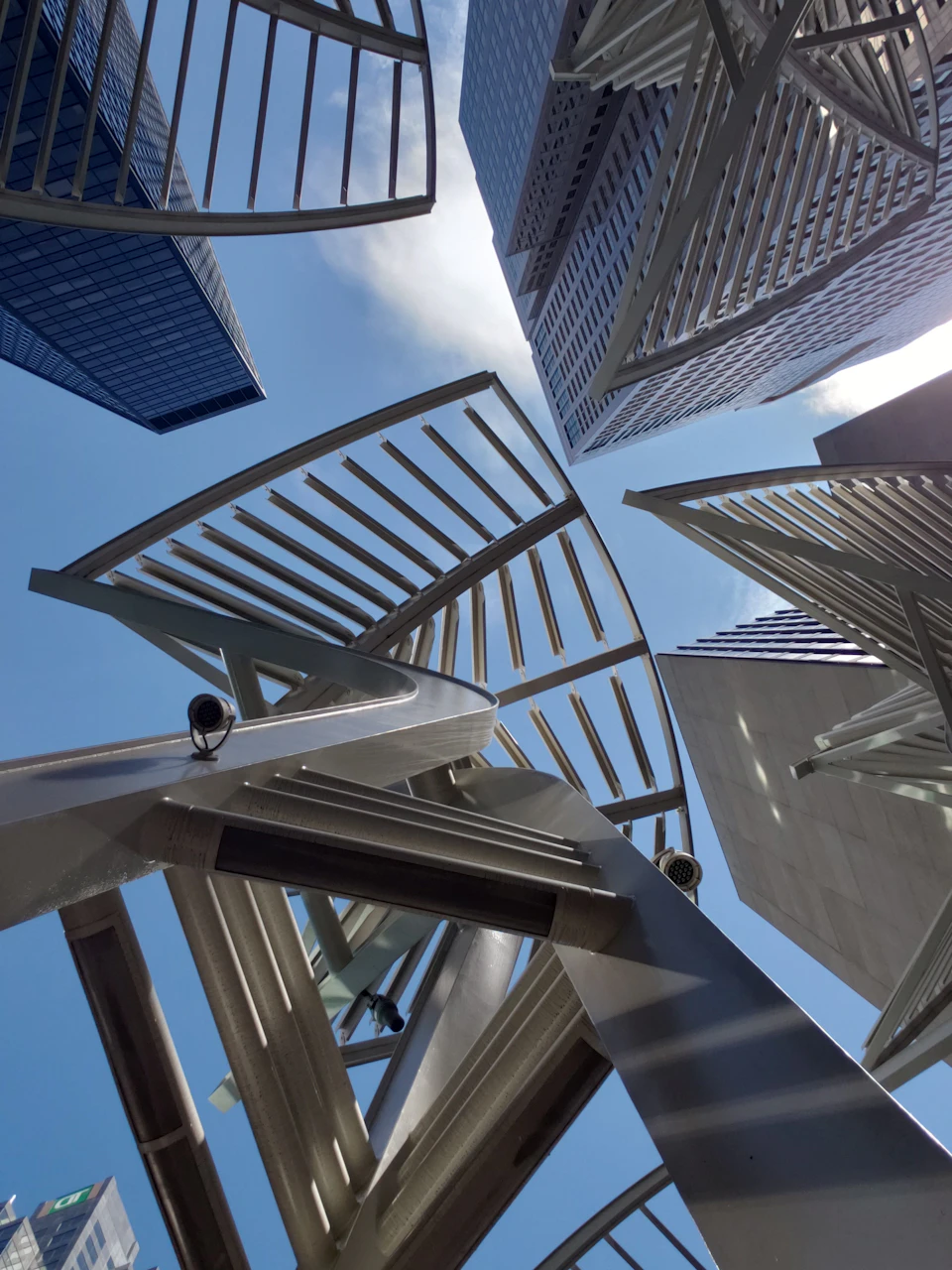 Triangular metal panels suspended by cables create intricate pattern in mid-air architecture
