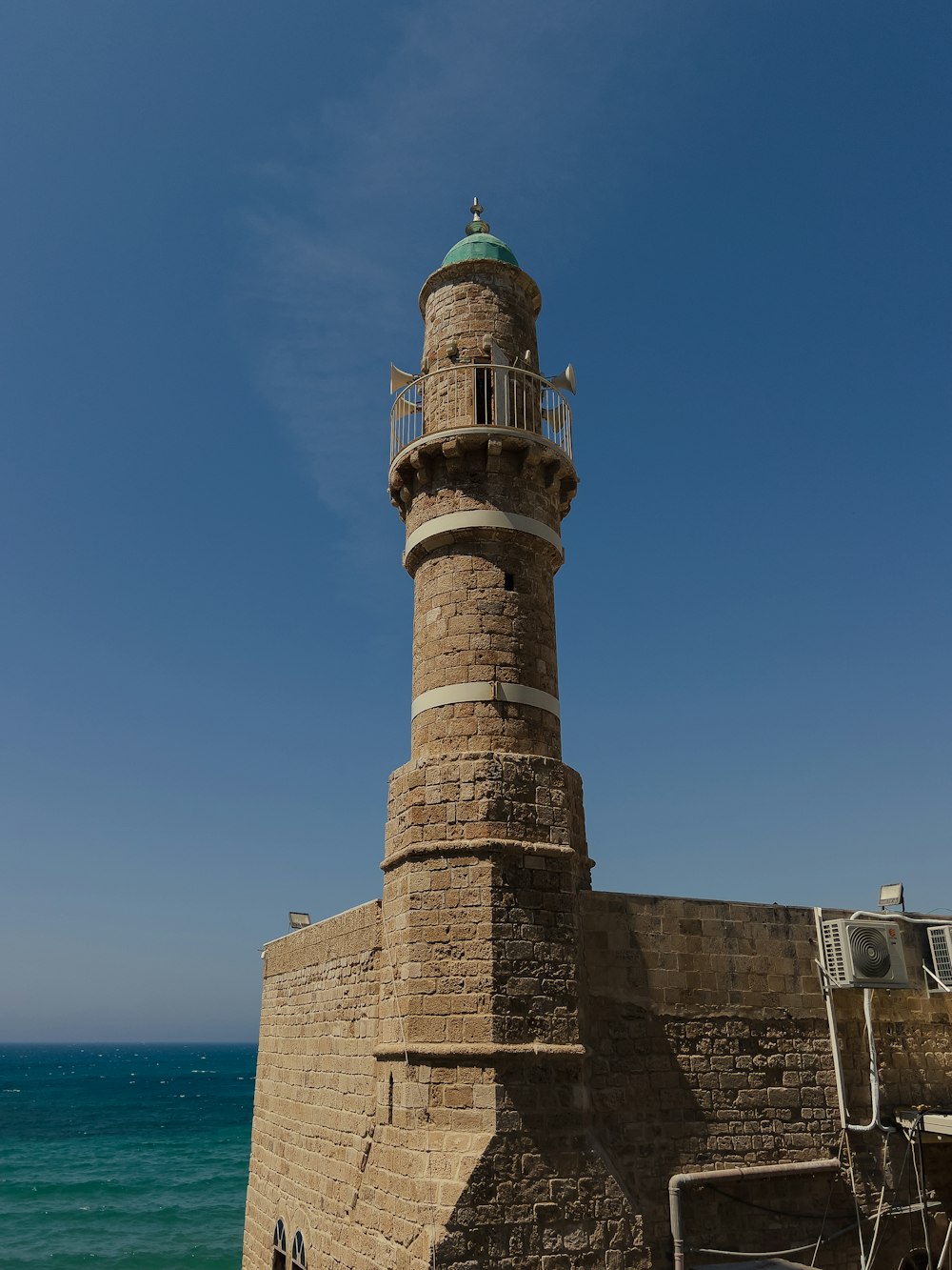 a light house sitting on top of a stone wall next to the ocean