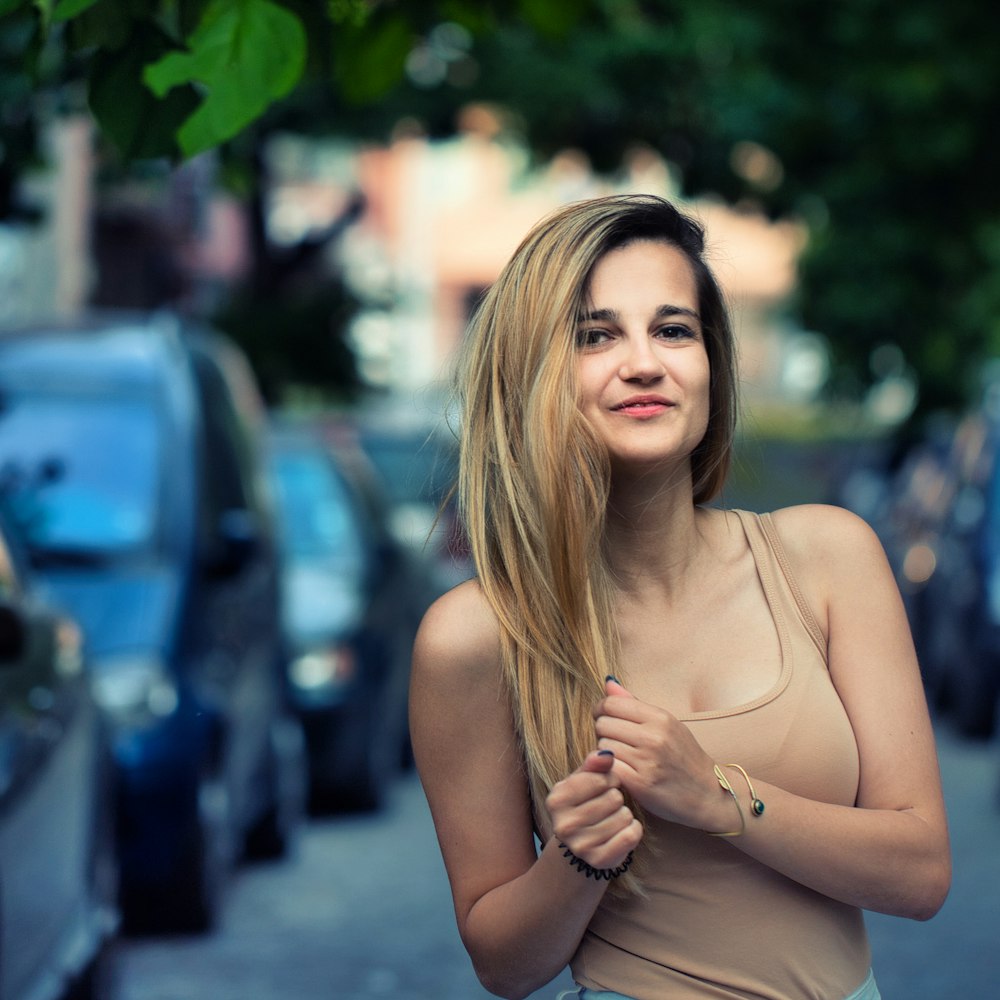 a woman with long hair standing on a street