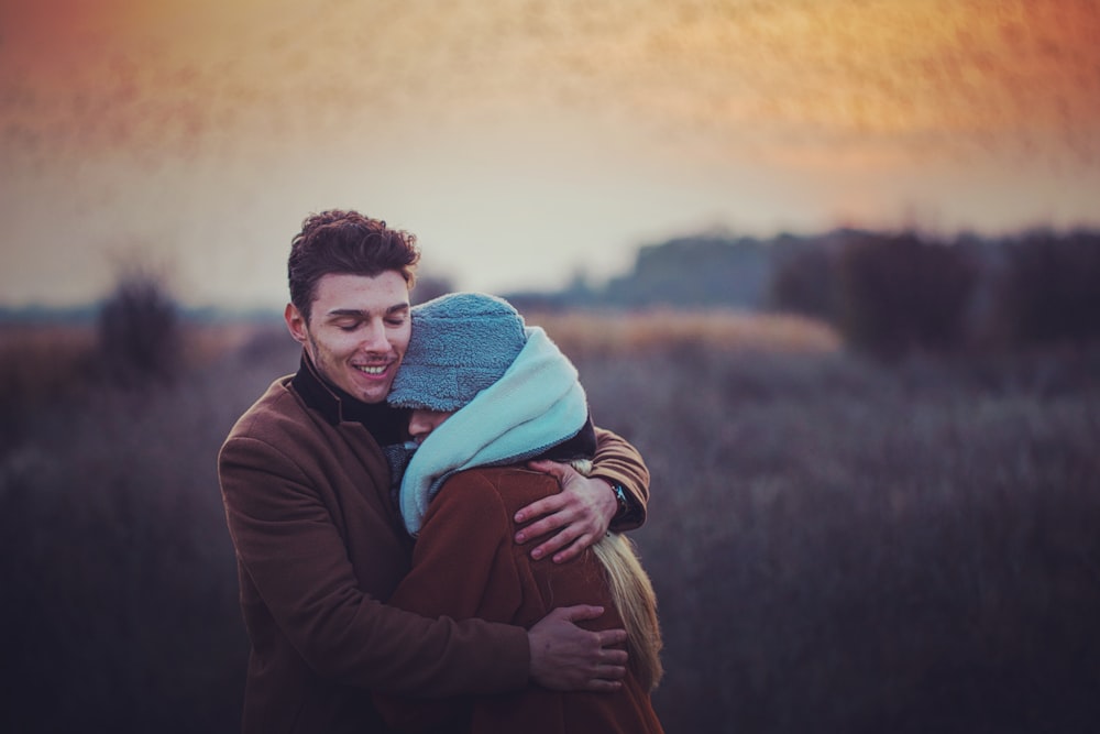 a man holding a woman in a field