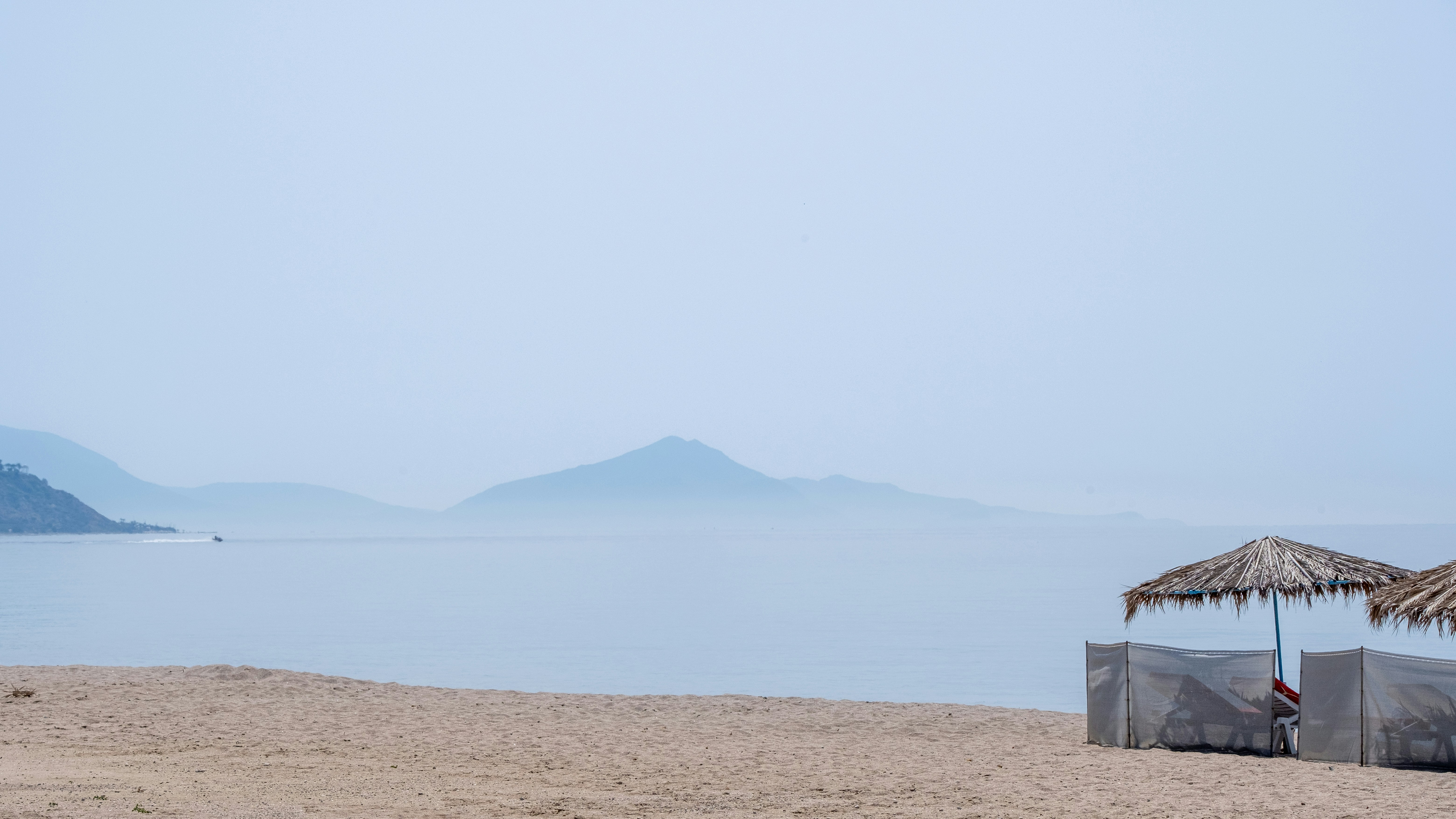 a couple of umbrellas sitting on top of a sandy beach