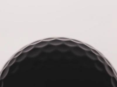 a close up of a black golf ball