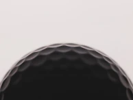 a close up of a black golf ball