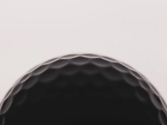 a close up of a black golf ball