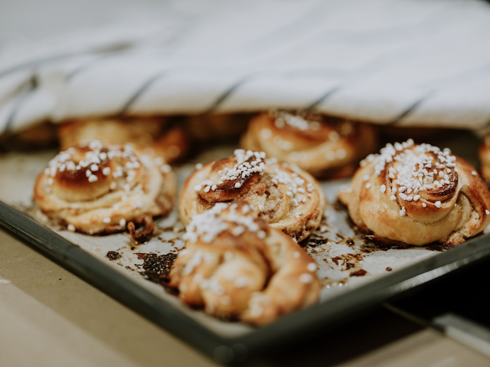 a tray filled with pastries covered in powdered sugar