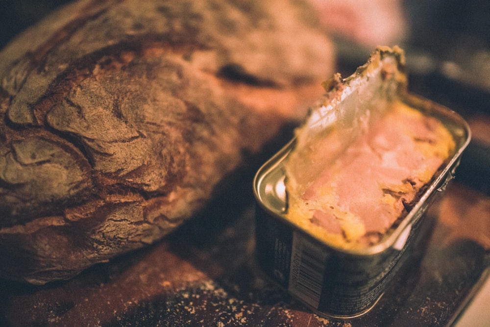 a loaf of bread sitting next to a can of food