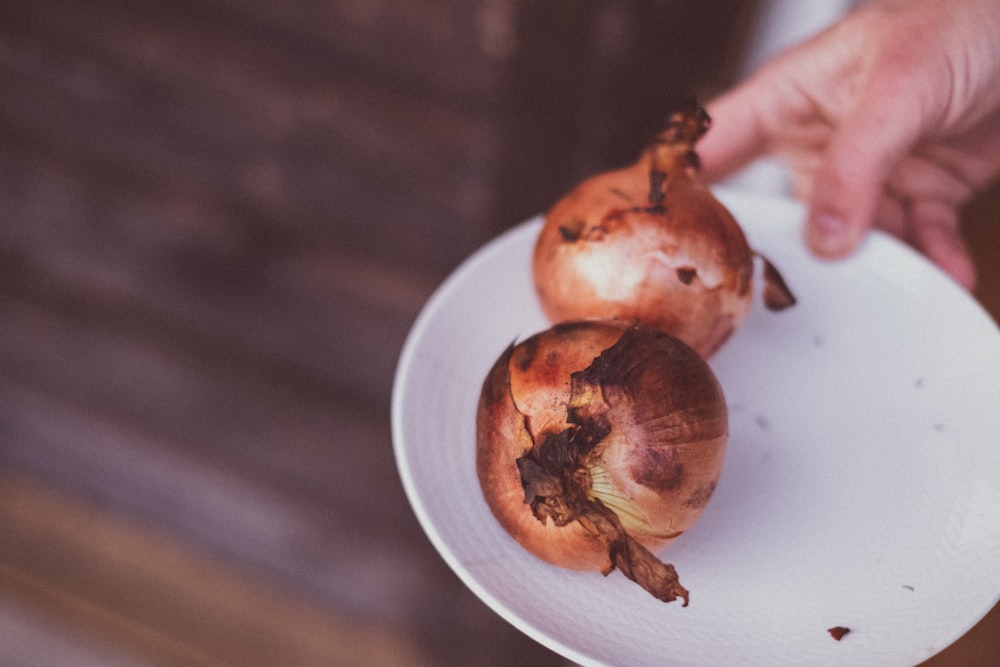 a person holding a plate with onions on it