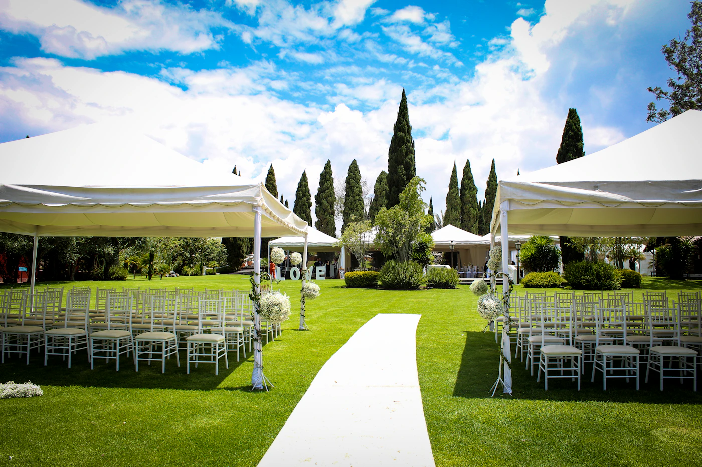 Rain backup plans for outdoor ceremonies in spring — A couple holding an umbrella during their rainy outdoor spring ceremony.
