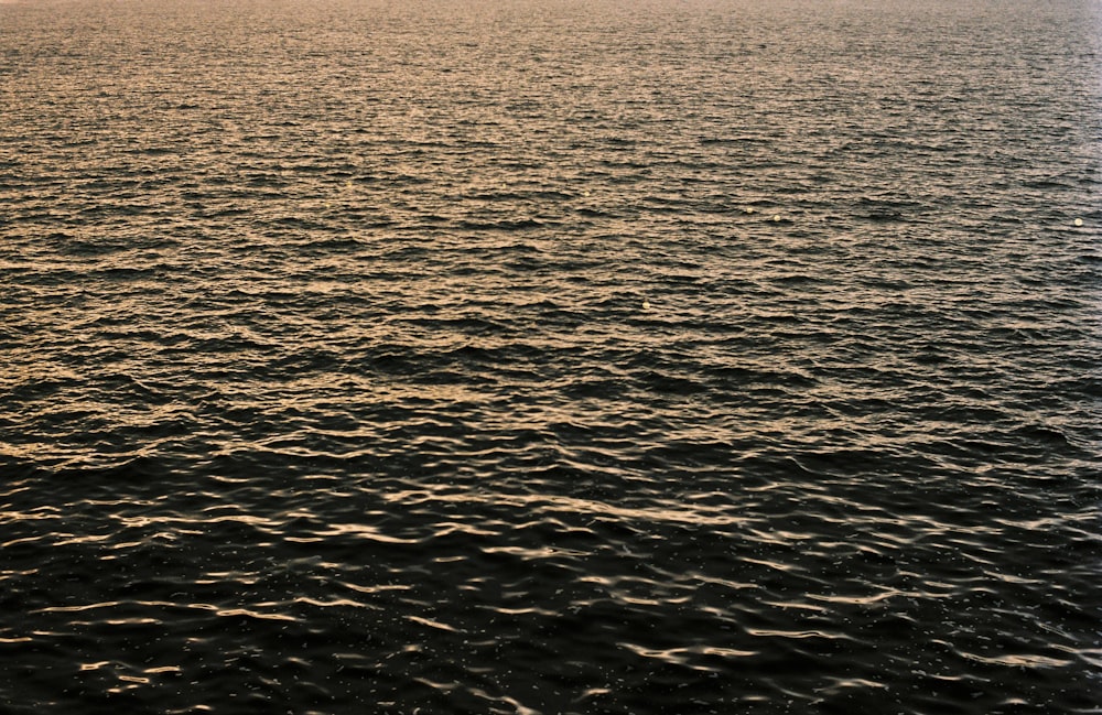 a large body of water with a boat in the distance