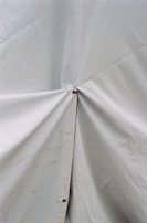 A close-up of a repair process on a canvas tarp.