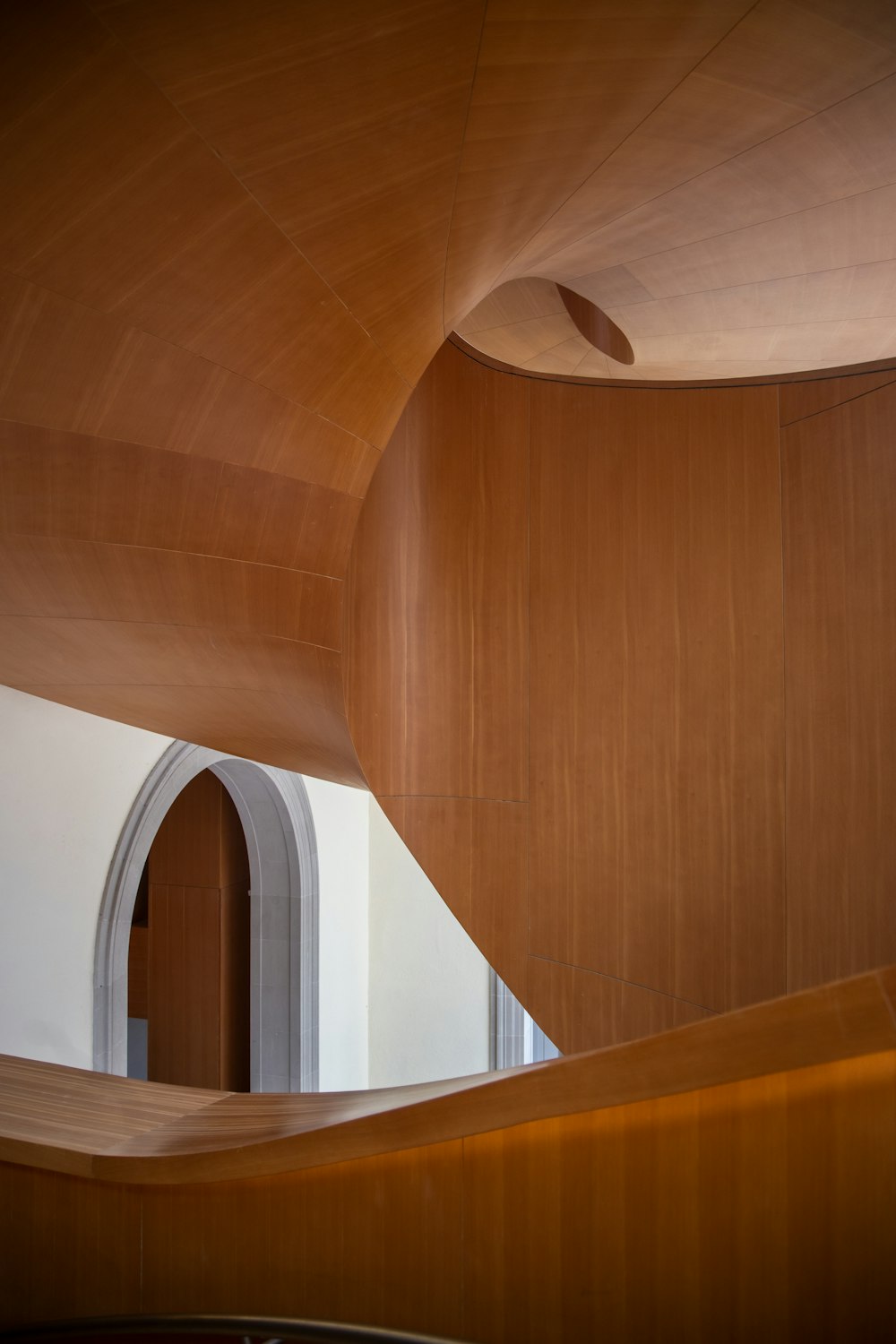 a curved room with a wooden ceiling and a window