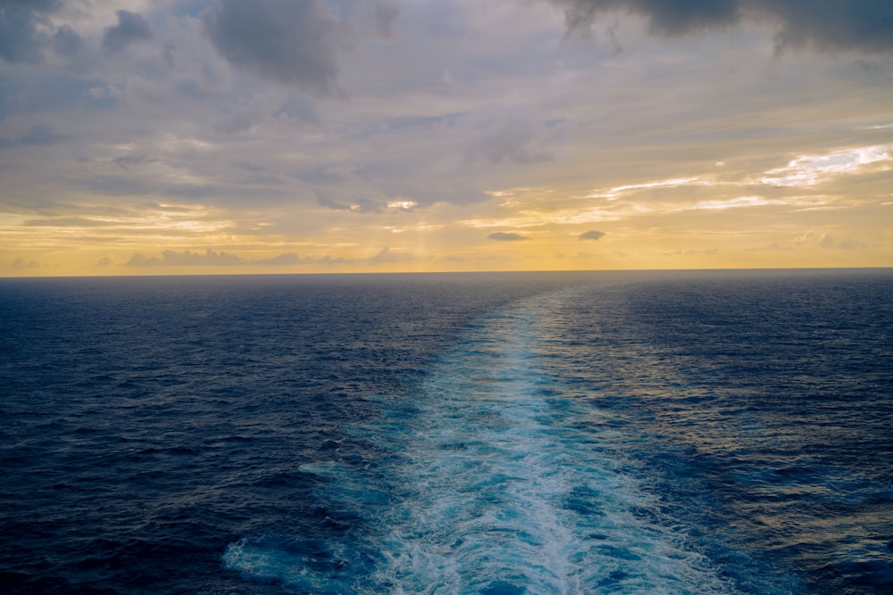 the wake of a boat in the ocean at sunset