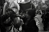 Warm-toned photo of a horse being gently loaded into a transport vehicle.