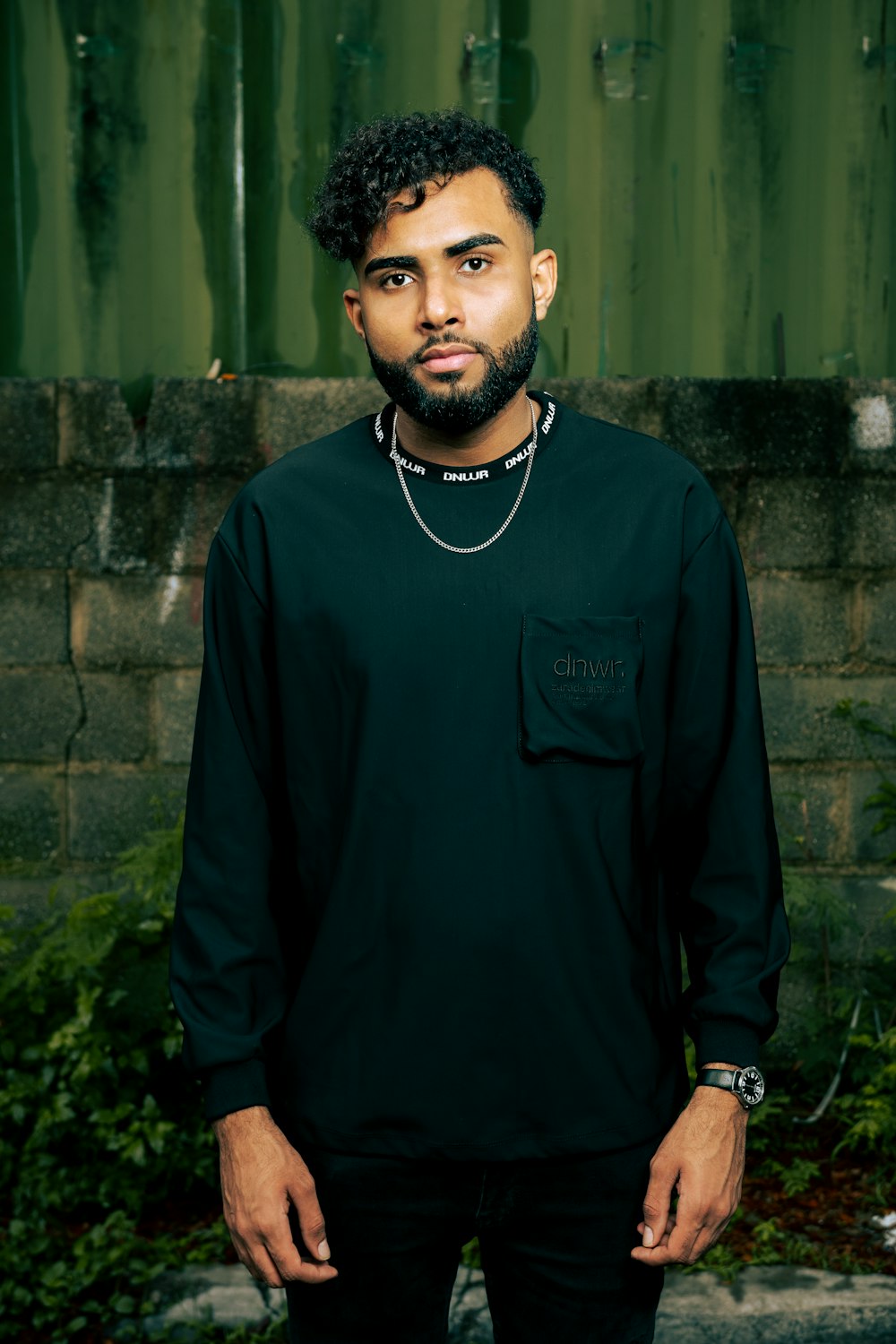 a man standing in front of a green wall