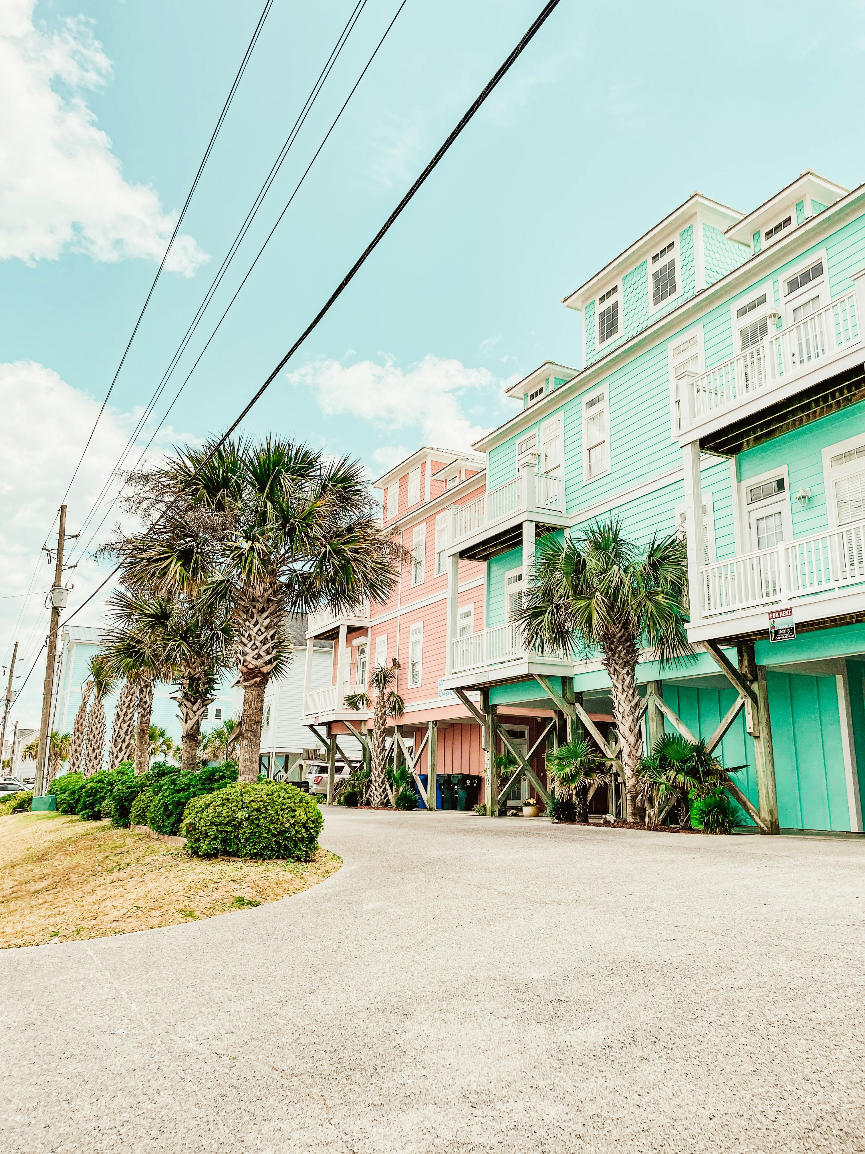 A row of multi - story houses with palm trees in front of them photo ...