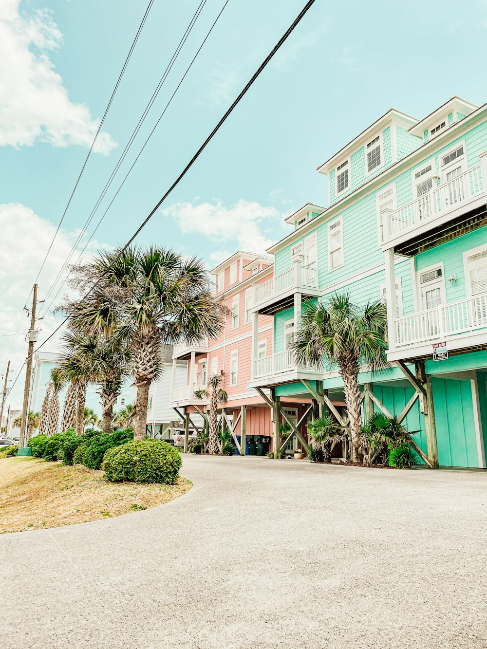 a row of multi - story houses with palm trees in front of them