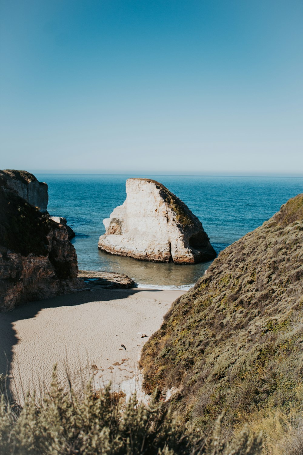 a large rock sticking out of the ocean