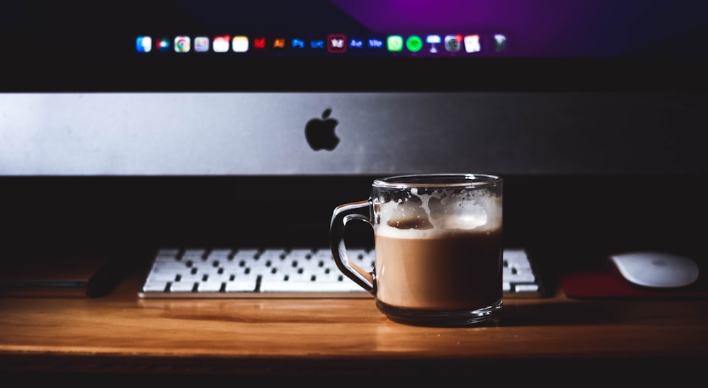 a cup of coffee sitting on top of a wooden table