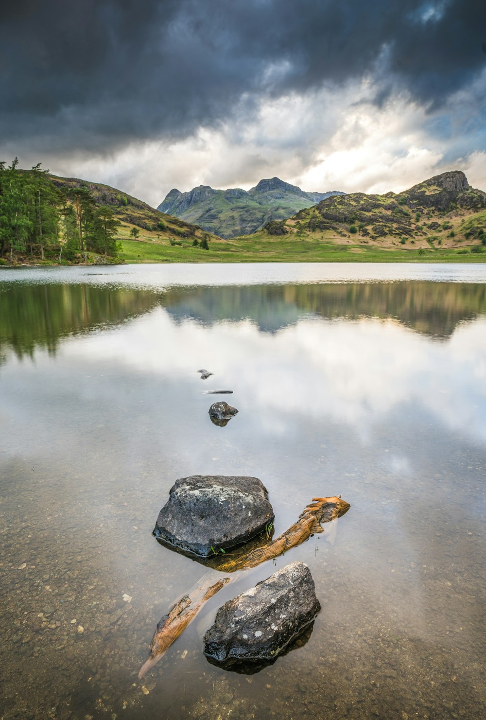 un plan d’eau entouré de montagnes sous un ciel nuageux