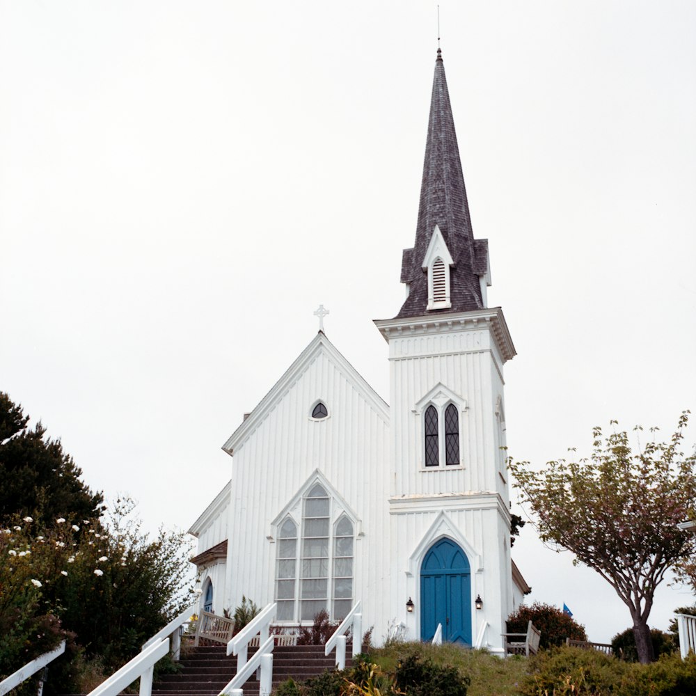 a white church with a blue door and steeple