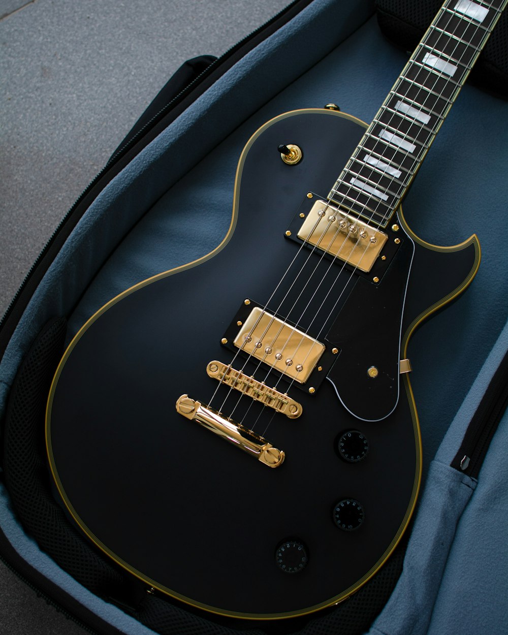 a black and gold electric guitar in a case