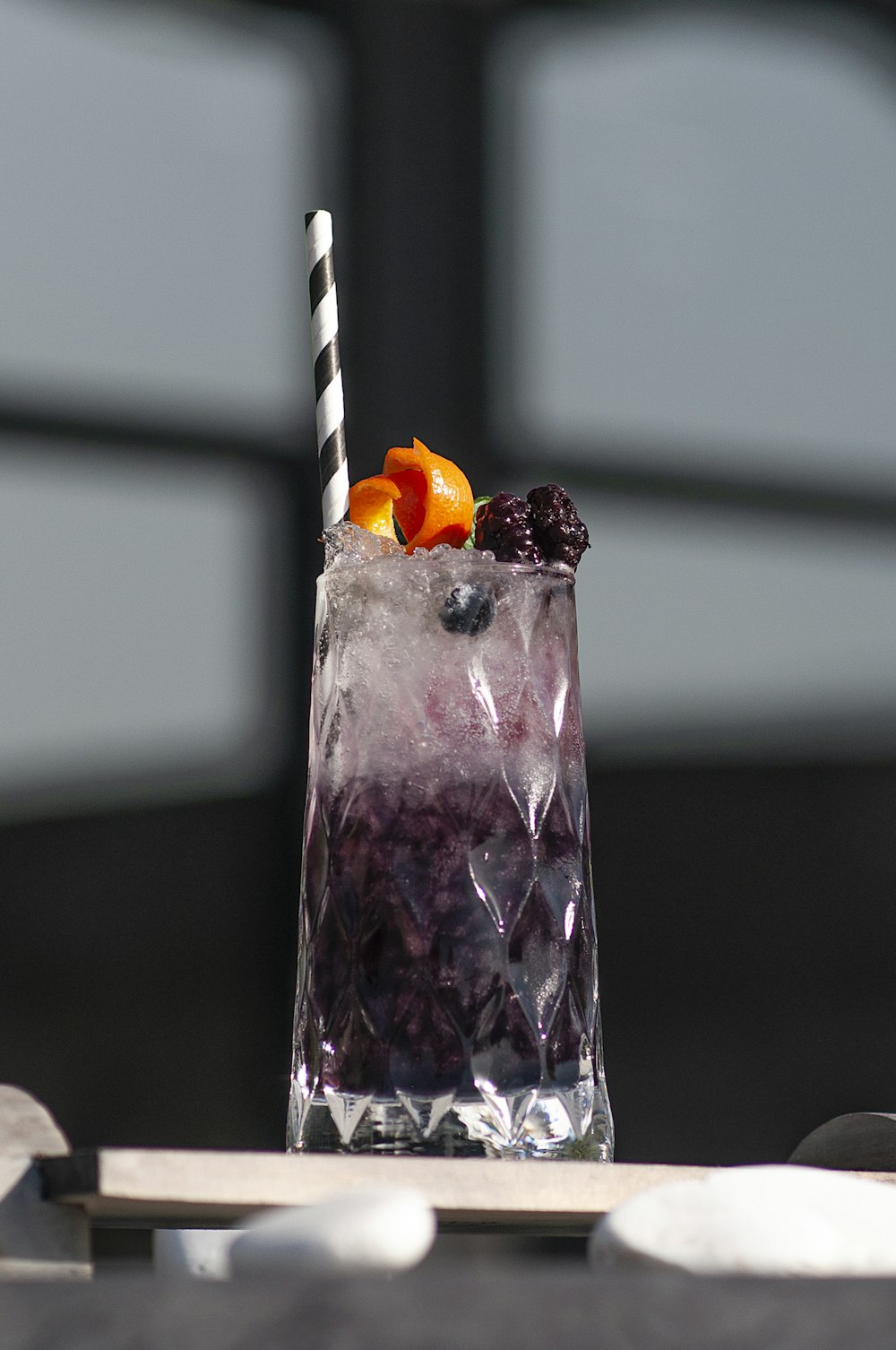 a tall glass filled with blueberries and oranges