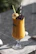 A tall glass of bright tropical smoothie garnished with a slice of pineapple and a straw.